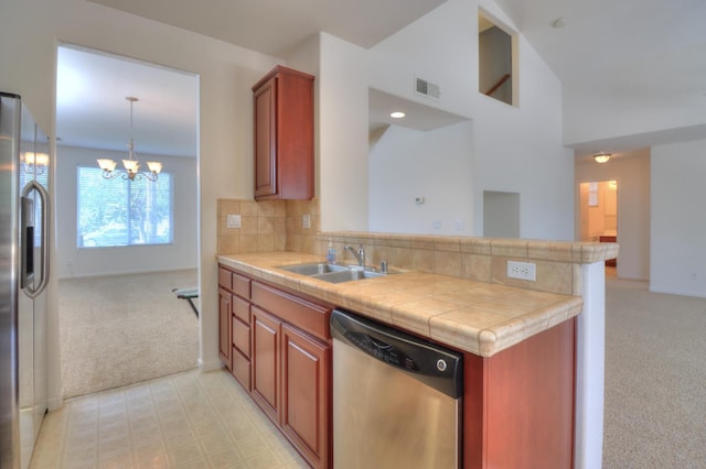 2062 Dunbar Way, Dinuba, CA 93618 - kitchen with appliances with stainless steel finishes, light colored carpet, a chandelier, a peninsula, and tasteful backsplash