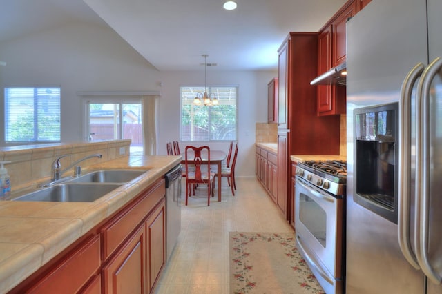 2062 Dunbar Way, Dinuba, CA 93618 - kitchen featuring appliances with stainless steel finishes, tile counters, a chandelier, hanging light fixtures, and under cabinet range hood