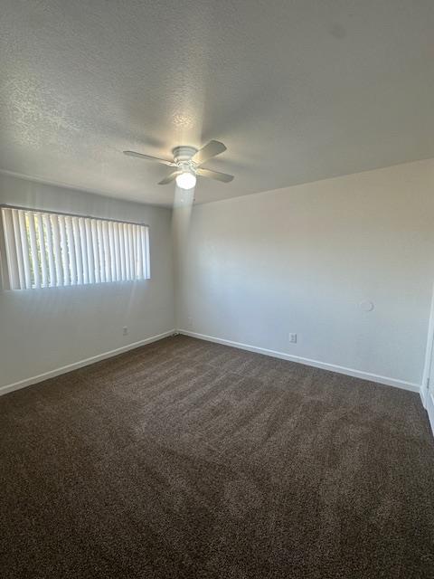 2967 E Iowa Ave, Fresno, CA 93701 - unfurnished room with ceiling fan, dark colored carpet, and a textured ceiling