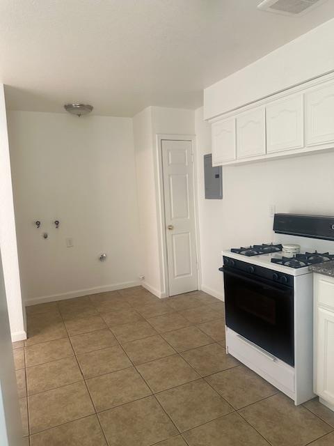 2967 E Iowa Ave, Fresno, CA 93701 - kitchen featuring range with gas stovetop, white cabinetry, tile patterned floors, and electric panel