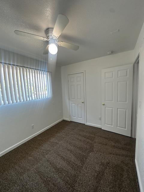2967 E Iowa Ave, Fresno, CA 93701 - unfurnished bedroom with carpet floors, a ceiling fan, and a textured ceiling