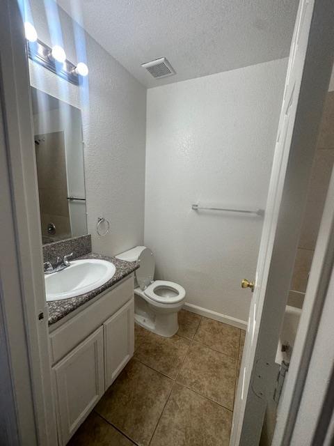 2967 E Iowa Ave, Fresno, CA 93701 - bathroom with vanity, tile patterned floors, a textured ceiling, and a textured wall
