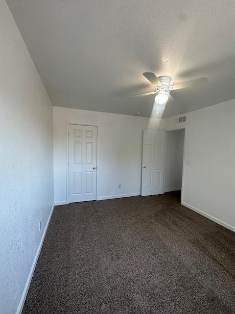 2967 E Iowa Ave, Fresno, CA 93701 - unfurnished bedroom with dark carpet and a ceiling fan