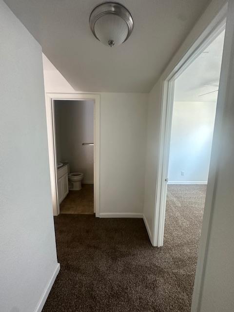 2967 E Iowa Ave, Fresno, CA 93701 - corridor featuring dark carpet and baseboards