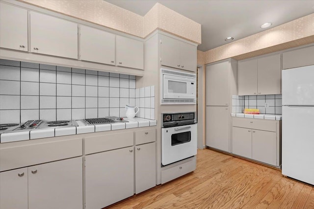 5532 N El Adobe Dr, Fresno, CA 93711 - kitchen with white appliances, tile counters, decorative backsplash, light wood-type flooring, and recessed lighting