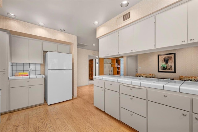 5532 N El Adobe Dr, Fresno, CA 93711 - kitchen with freestanding refrigerator, light wood-type flooring, tile countertops, recessed lighting, and white cabinets