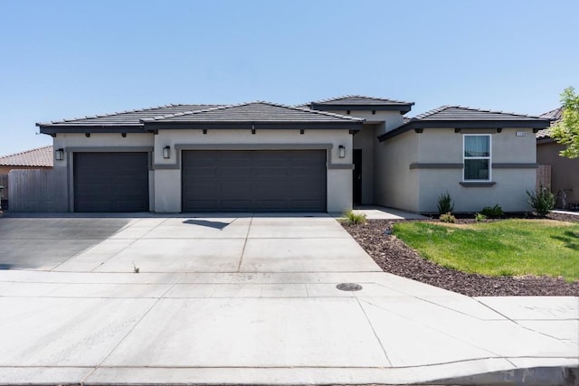 1160 Summit Ct, Madera, CA 93638 - prairie-style home featuring a garage, driveway, stucco siding, and a tiled roof