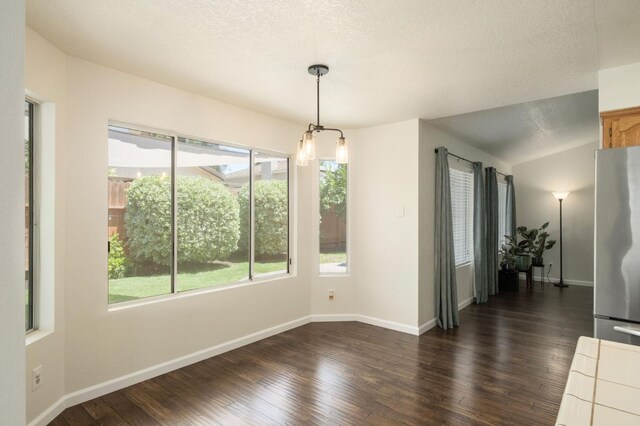 841 Whittier Ave, Clovis, CA 93611 - unfurnished dining area with dark wood-type flooring, a textured ceiling, a chandelier, and lofted ceiling