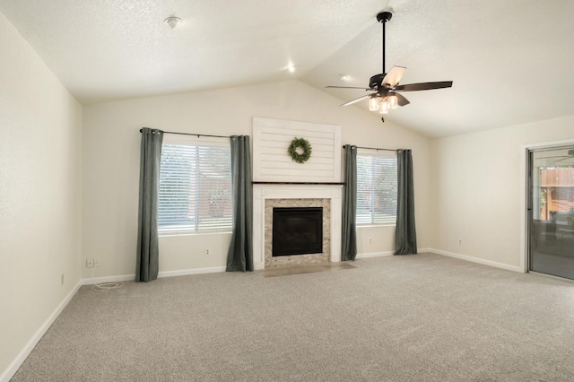 841 Whittier Ave, Clovis, CA 93611 - unfurnished living room featuring vaulted ceiling, carpet floors, plenty of natural light, ceiling fan, and a fireplace with flush hearth