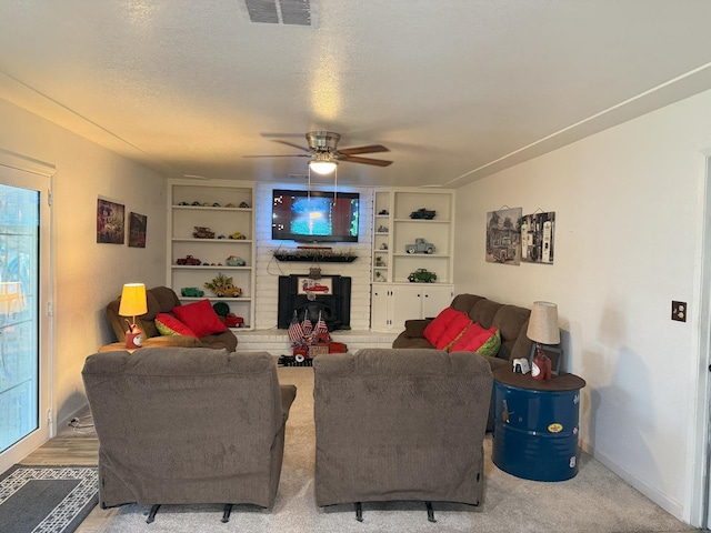 605 E Davis Dr, Dinuba, CA 93618 - living room featuring ceiling fan, a brick fireplace, built in shelves, and plenty of natural light