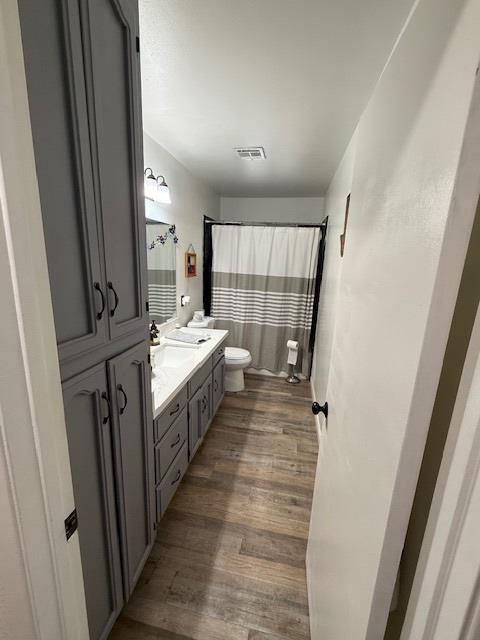 605 E Davis Dr, Dinuba, CA 93618 - full bath with double vanity, wood finished floors, and curtained shower