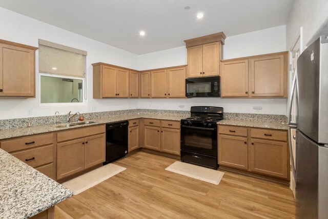 17 Medieval, Merced, CA 95341 - kitchen featuring black appliances, light stone countertops, light wood-style flooring, and recessed lighting