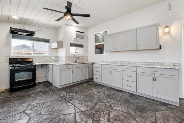 17 Medieval, Merced, CA 95341 - kitchen with black gas range, gray cabinetry, a ceiling fan, a wall mounted air conditioner, and decorative backsplash
