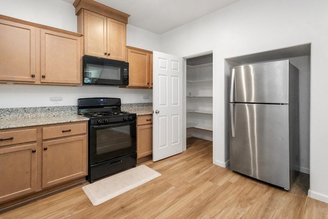 17 Medieval, Merced, CA 95341 - kitchen with black appliances, light wood-style flooring, and light stone countertops