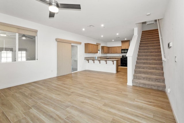 17 Medieval, Merced, CA 95341 - unfurnished living room with a ceiling fan, stairway, light wood-style flooring, and recessed lighting