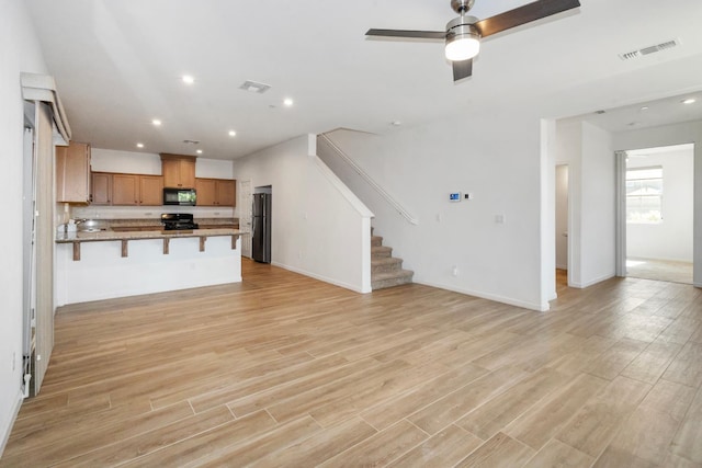 17 Medieval, Merced, CA 95341 - unfurnished living room featuring a ceiling fan, stairs, light wood-type flooring, and recessed lighting
