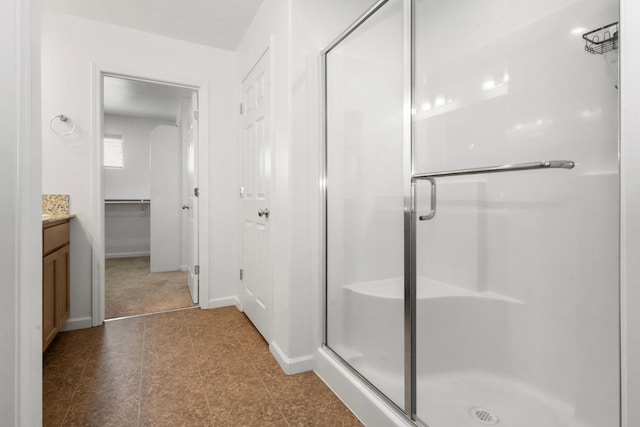 17 Medieval, Merced, CA 95341 - bathroom featuring a stall shower, vanity, a spacious closet, and tile patterned floors