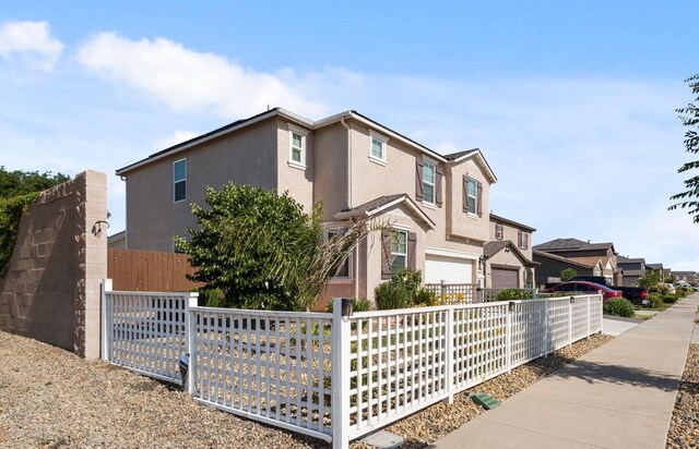 17 Medieval, Merced, CA 95341 - view of front of home with stucco siding, a garage, and a residential view