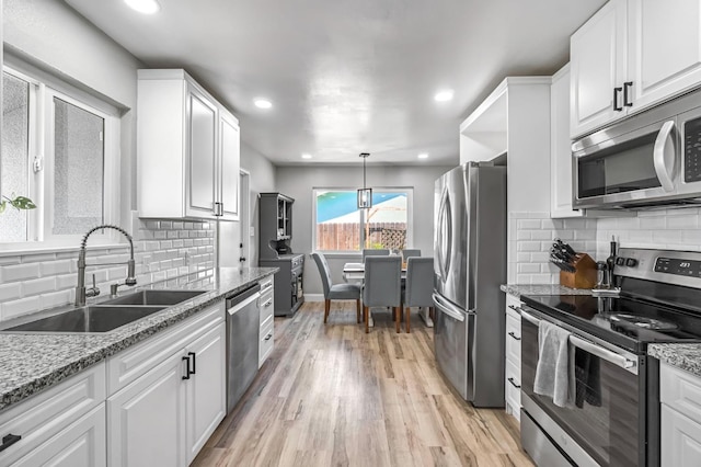 42 W Rall Ave, Clovis, CA 93612 - kitchen with appliances with stainless steel finishes, light wood finished floors, white cabinetry, decorative backsplash, and recessed lighting