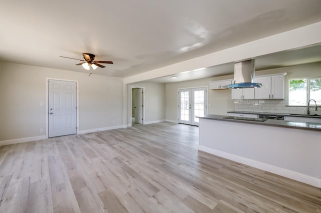 17189 Iona Ave, Lemoore, CA 93245 - kitchen with island exhaust hood, dark countertops, french doors, and white cabinetry