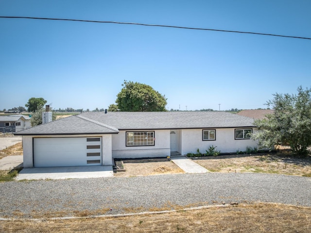 17189 Iona Ave, Lemoore, CA 93245 - single story home with an attached garage, stucco siding, gravel driveway, a shingled roof, and a chimney