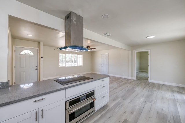 17189 Iona Ave, Lemoore, CA 93245 - kitchen with black electric cooktop, oven, island exhaust hood, and white cabinetry