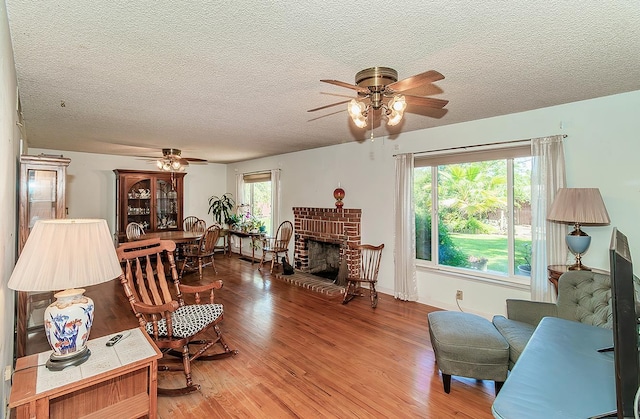 5432 E Swift Ave, Fresno, CA 93727 - living area with a ceiling fan, light wood-style floors, a textured ceiling, and a fireplace