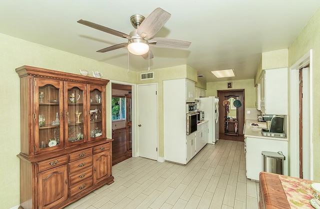 5432 E Swift Ave, Fresno, CA 93727 - kitchen featuring light countertops, a ceiling fan, stainless steel oven, freestanding refrigerator, and white cabinetry