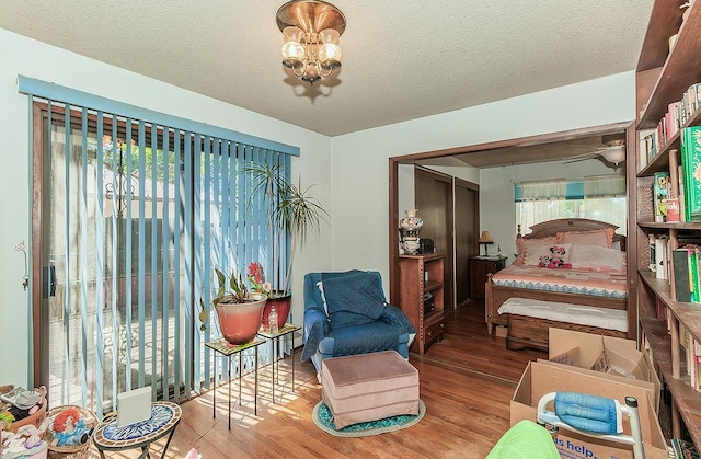 5432 E Swift Ave, Fresno, CA 93727 - bedroom featuring wood finished floors, a chandelier, and a textured ceiling