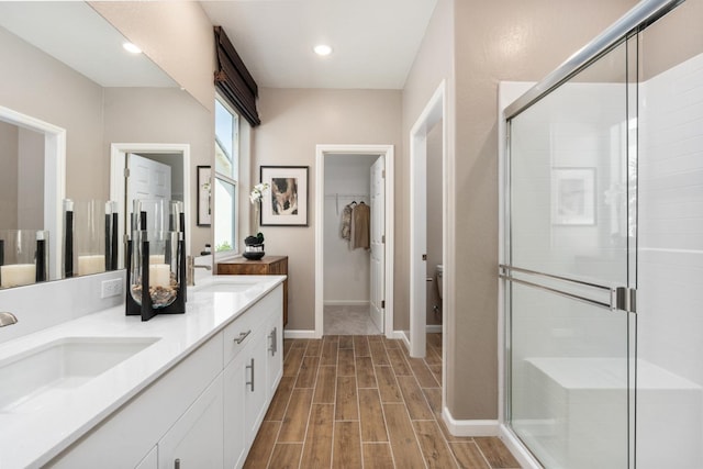 1473 Bloom Ln, Clovis, CA 93619 - bathroom featuring double vanity, a shower stall, and wood finished floors