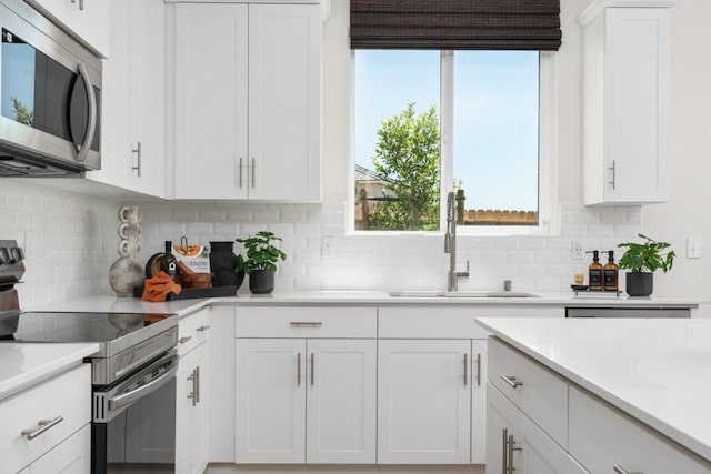 1473 Bloom Ln, Clovis, CA 93619 - kitchen with stainless steel appliances, light countertops, white cabinets, and backsplash