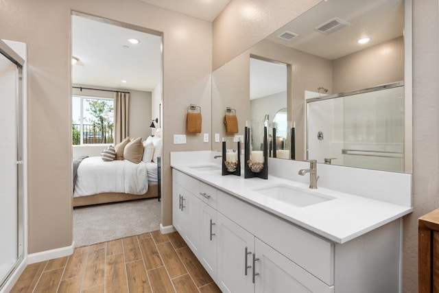1473 Bloom Ln, Clovis, CA 93619 - ensuite bathroom featuring double vanity, wood finished floors, a stall shower, and recessed lighting