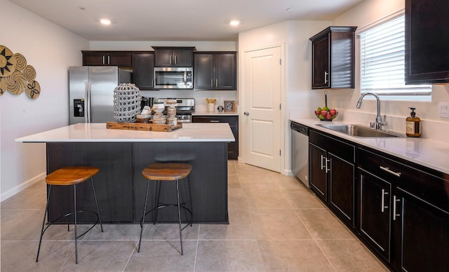 2018 Catherine Ave Unit 2043S, Sanger, CA 93657 - kitchen featuring appliances with stainless steel finishes, a kitchen breakfast bar, light countertops, a kitchen island, and light tile patterned floors