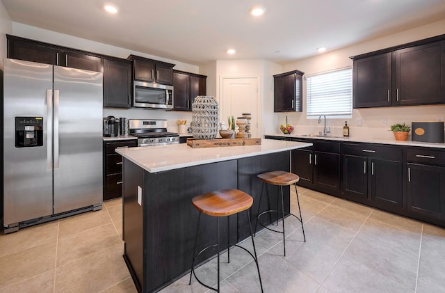 2018 Catherine Ave Unit 2043S, Sanger, CA 93657 - kitchen featuring stainless steel appliances, a breakfast bar area, light countertops, a center island, and light tile patterned flooring
