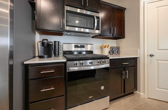 2018 Catherine Ave Unit 2043S, Sanger, CA 93657 - kitchen featuring appliances with stainless steel finishes, light countertops, light tile patterned floors, and dark brown cabinets