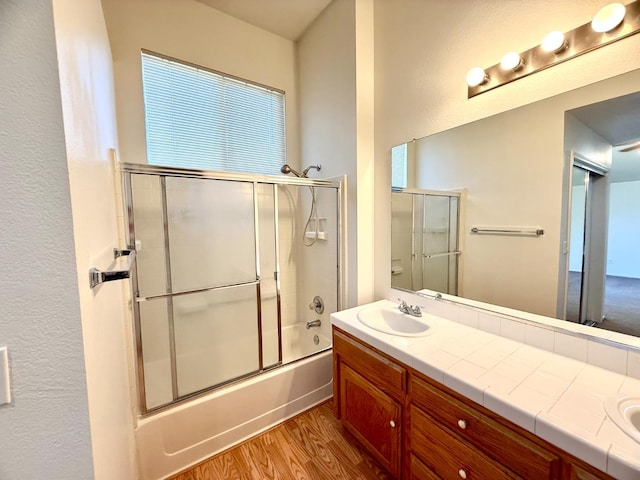 4688 W Weldon Ave, Fresno, CA 93722 - bathroom with wood finished floors, double vanity, and enclosed tub / shower combo