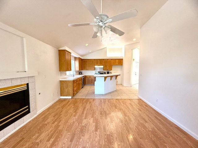 4688 W Weldon Ave, Fresno, CA 93722 - kitchen with brown cabinets, light countertops, ceiling fan, light wood finished floors, and lofted ceiling
