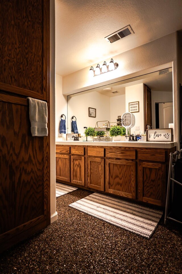 10080 N Dearing Ave, Fresno, CA 93730 - bathroom featuring double vanity and a textured ceiling