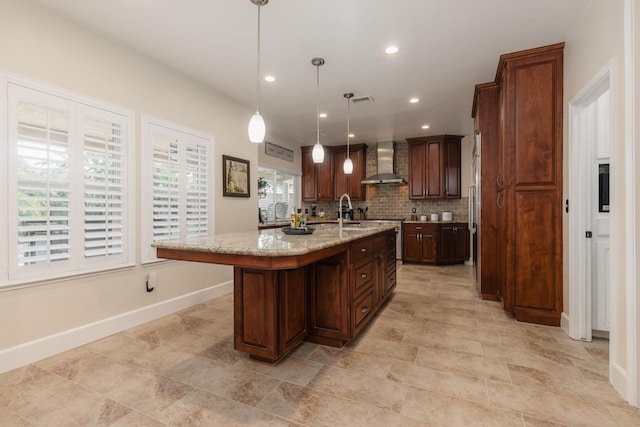 1199 E Cole Ave, Fresno, CA 93720 - kitchen with wall chimney range hood, a center island with sink, recessed lighting, light stone counters, and hanging light fixtures