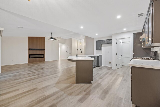 2540 E Seeger Ave, Visalia, CA 93292 - kitchen featuring range, a ceiling fan, light wood-style floors, a large fireplace, and open floor plan