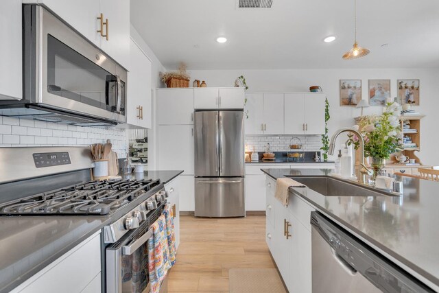 1961 Oak Ln, Clovis, CA 93611 - kitchen with stainless steel appliances, backsplash, white cabinets, light wood-type flooring, and recessed lighting