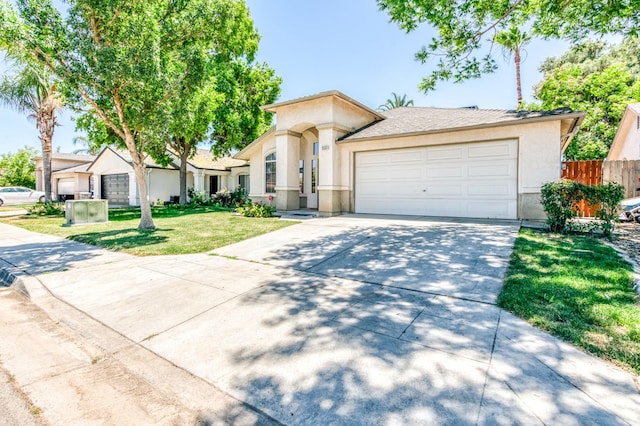 5537 W Oswego Ave, Fresno, CA 93722 - view of front facade with stucco siding, driveway, and a garage