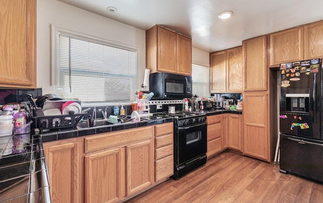 2004 E Clinton Ave, Fresno, CA 93703 - kitchen with black appliances, tile counters, light wood-style floors, recessed lighting, and backsplash