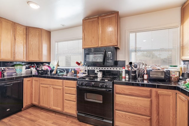 2004 E Clinton Ave, Fresno, CA 93703 - kitchen with black appliances, plenty of natural light, and decorative backsplash