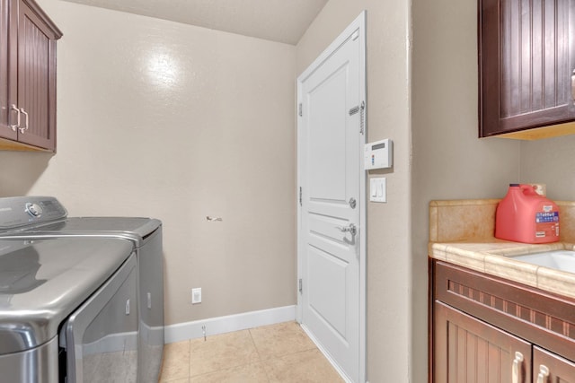 3017 W Oleander Ave, Fresno, CA 93706 - washroom with cabinet space, washing machine and clothes dryer, and light tile patterned floors