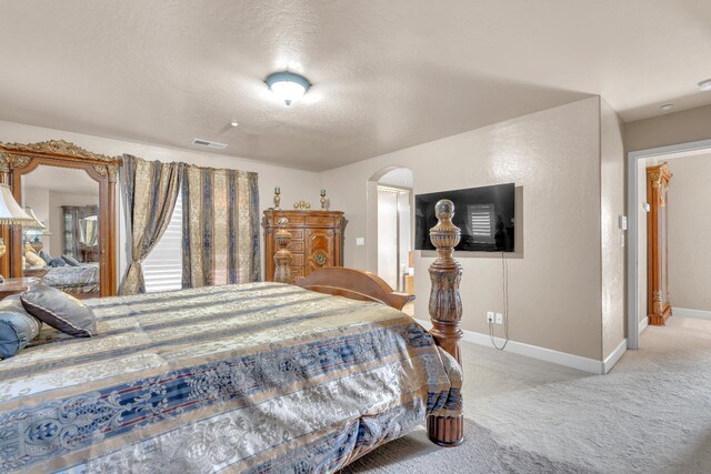 3017 W Oleander Ave, Fresno, CA 93706 - bedroom featuring light carpet, arched walkways, and a textured ceiling