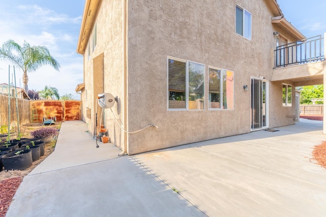 3017 W Oleander Ave, Fresno, CA 93706 - view of side of property with stucco siding, a balcony, and a patio area