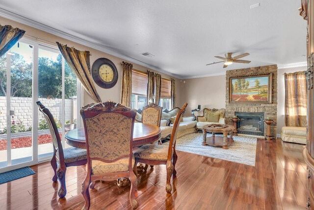 3017 W Oleander Ave, Fresno, CA 93706 - dining area featuring crown molding, ceiling fan, wood finished floors, and a stone fireplace