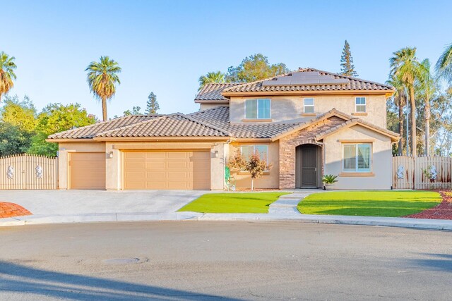 3017 W Oleander Ave, Fresno, CA 93706 - mediterranean / spanish-style house featuring stucco siding, an attached garage, solar panels, and concrete driveway