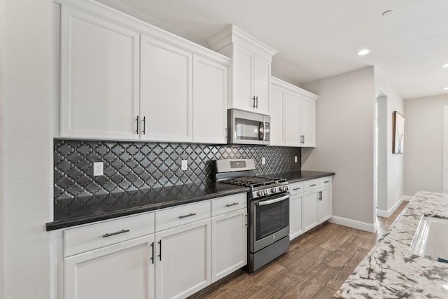 3430 Hermosa Ave, Clovis, CA 93619 - kitchen featuring appliances with stainless steel finishes, backsplash, white cabinets, wood finished floors, and recessed lighting